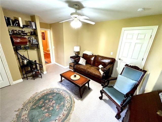 carpeted living room with baseboards and a ceiling fan