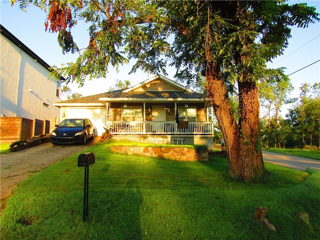 view of front of home with a front yard, a garage, and a porch