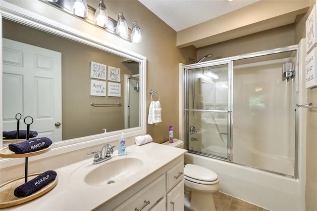 full bath with toilet, vanity, tile patterned flooring, and shower / bath combination with glass door