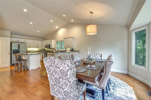 dining area featuring recessed lighting, light wood-style floors, high vaulted ceiling, visible vents, and baseboards