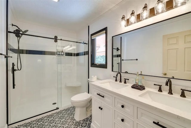 bathroom featuring a stall shower, toilet, double vanity, and a sink