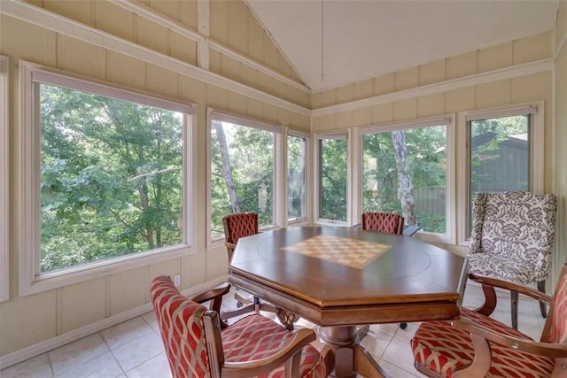 sunroom featuring tile patterned flooring, lofted ceiling, and a healthy amount of sunlight