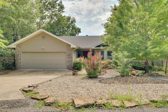 ranch-style home featuring driveway, brick siding, and a garage
