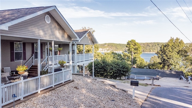 view of yard with a water view and covered porch