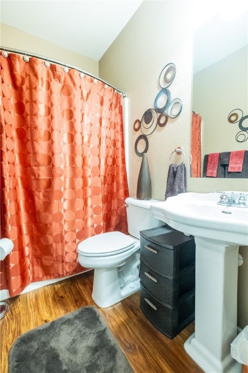 bathroom with a shower with shower curtain, toilet, and hardwood / wood-style flooring