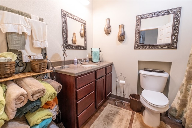 bathroom with vanity, toilet, and hardwood / wood-style flooring