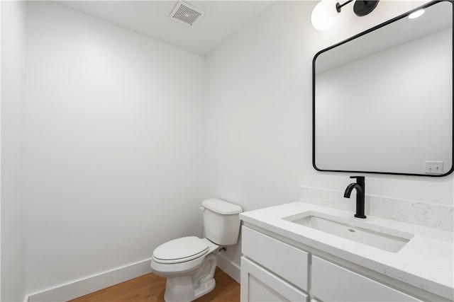 bathroom featuring wood-type flooring, toilet, and vanity