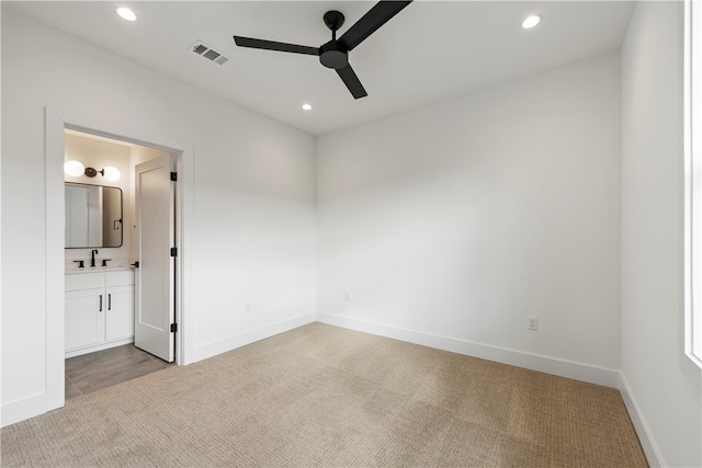 unfurnished bedroom with sink, connected bathroom, ceiling fan, and light colored carpet