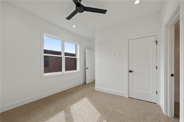 unfurnished bedroom with ceiling fan and light colored carpet