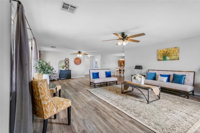 living room with light hardwood / wood-style flooring and ceiling fan