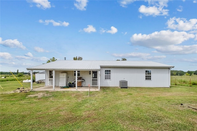 back of property featuring a yard, cooling unit, and a patio area