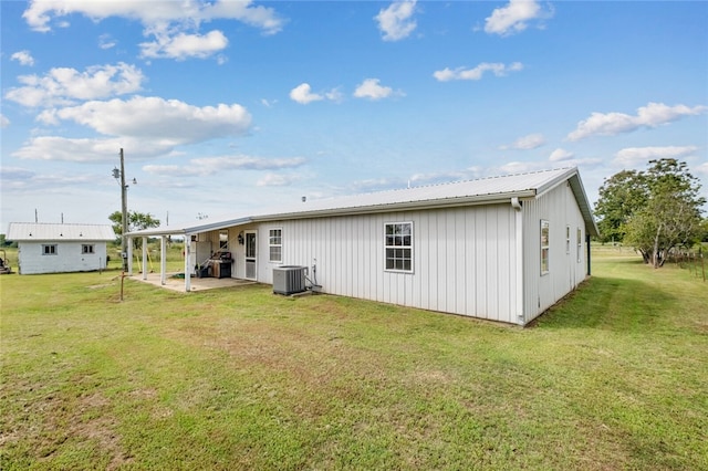 rear view of house featuring a yard, cooling unit, and a patio