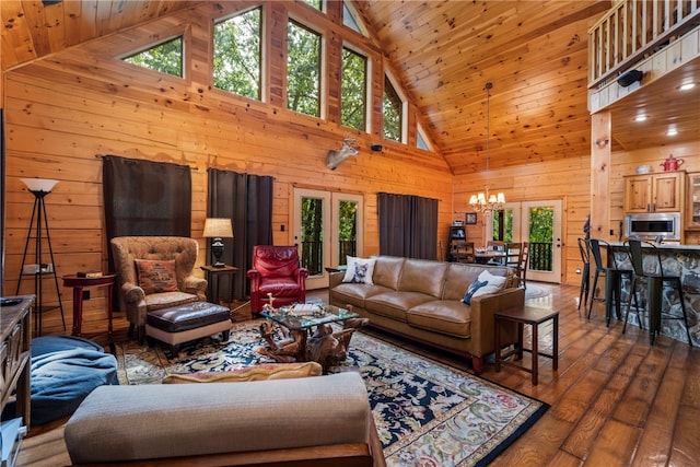 living room with high vaulted ceiling, a notable chandelier, wood walls, wooden ceiling, and hardwood / wood-style flooring