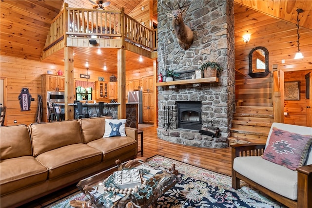 living room with hardwood / wood-style floors, high vaulted ceiling, and wooden walls