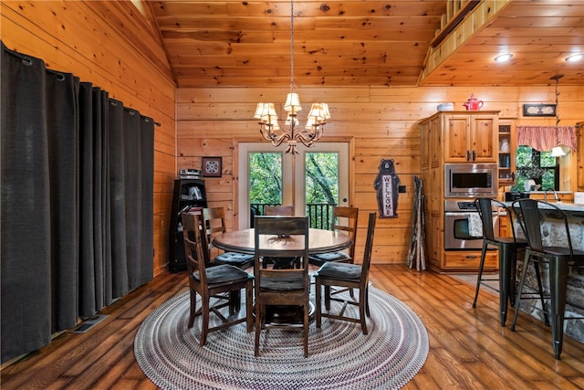 dining area featuring an inviting chandelier, vaulted ceiling, wood ceiling, dark wood-type flooring, and wood walls