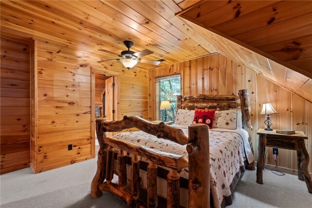 carpeted bedroom with wooden ceiling, vaulted ceiling, wood walls, and ceiling fan