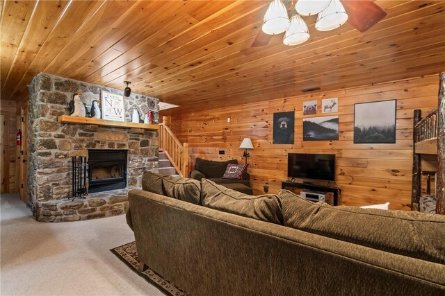 living room with a fireplace, wooden walls, carpet flooring, wood ceiling, and ceiling fan