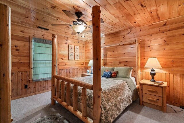 carpeted bedroom featuring wood ceiling, wooden walls, and ceiling fan