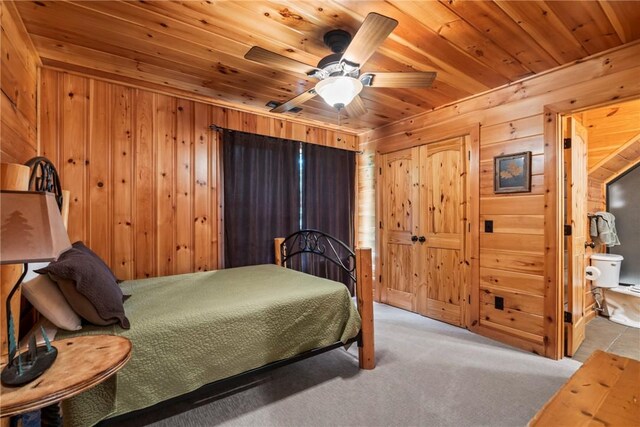 carpeted bedroom featuring wood walls, ceiling fan, and wood ceiling