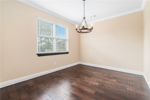 empty room featuring dark hardwood / wood-style floors, a chandelier, and crown molding