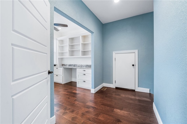 foyer with built in desk, ceiling fan, and dark wood-type flooring