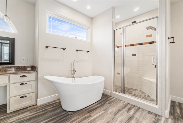 bathroom with vanity, hardwood / wood-style floors, and separate shower and tub