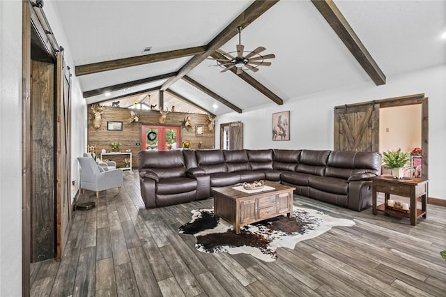 living room with lofted ceiling with beams, wood-type flooring, ceiling fan, and a barn door