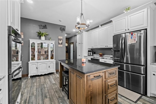 kitchen with an inviting chandelier, a center island, dark hardwood / wood-style floors, stainless steel refrigerator with ice dispenser, and white cabinets