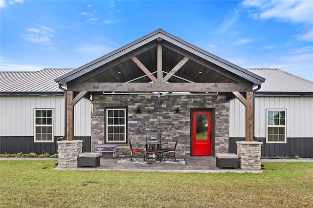 back of property featuring a patio area and a lawn