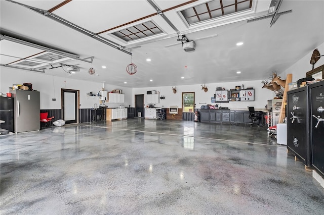 garage featuring a garage door opener and stainless steel fridge