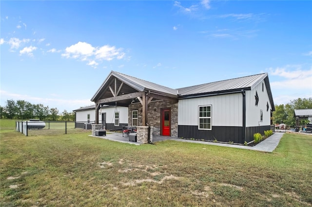 back of house featuring a lawn and a patio area