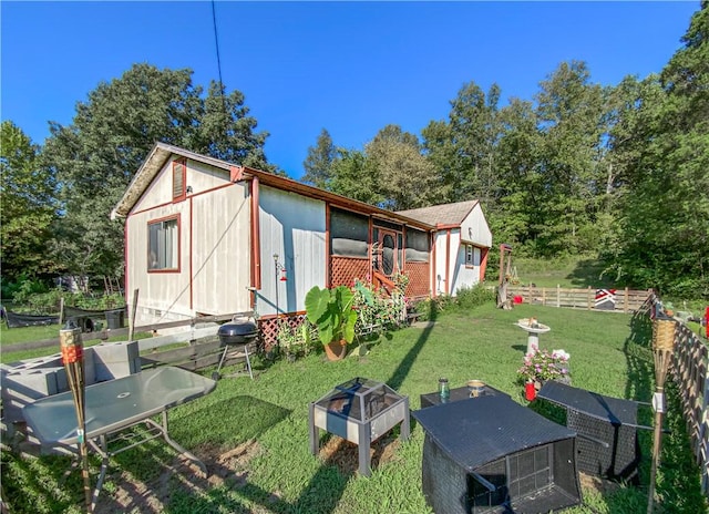 view of outbuilding featuring an outbuilding, an outdoor fire pit, and fence