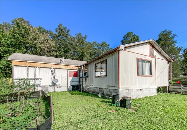 view of front of house with a front lawn, a garden, fence, and crawl space