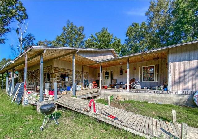 back of property featuring a lawn and covered porch