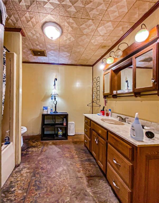 full bathroom with visible vents, toilet, ornamental molding, walk in shower, and vanity