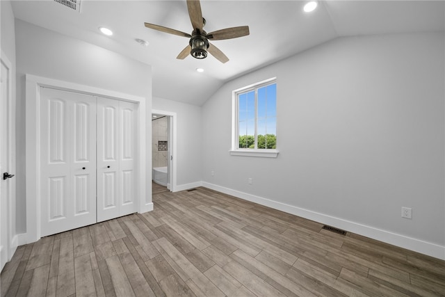 unfurnished bedroom featuring vaulted ceiling, a closet, ceiling fan, and light hardwood / wood-style floors