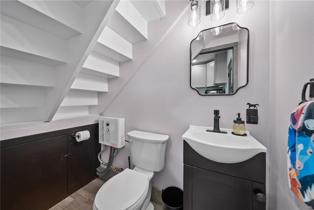 bathroom with vanity, toilet, and wood-type flooring