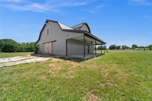 view of side of property with a lawn and cooling unit