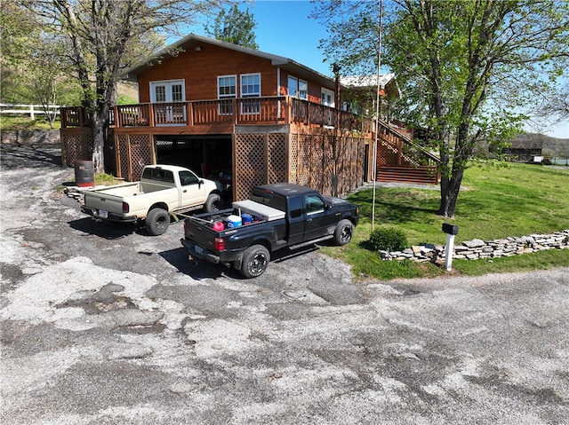 view of front of home with a wooden deck and a front lawn