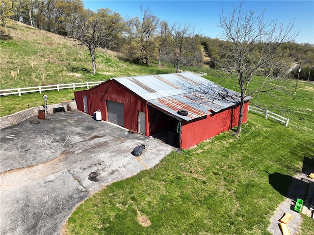 view of outdoor structure featuring a yard, a rural view, and a garage