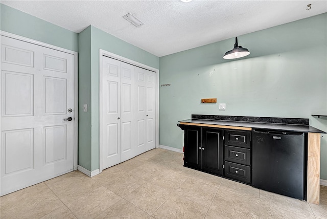 bar featuring dishwasher and a textured ceiling