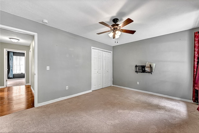 unfurnished bedroom with hardwood / wood-style floors, ceiling fan, a closet, and a textured ceiling