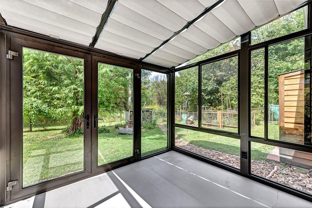 unfurnished sunroom featuring vaulted ceiling