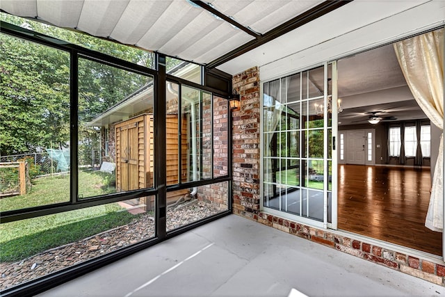 unfurnished sunroom with ceiling fan