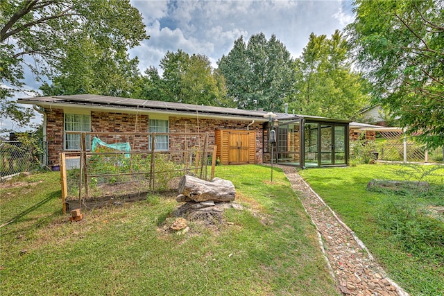 rear view of property featuring a sunroom and a yard