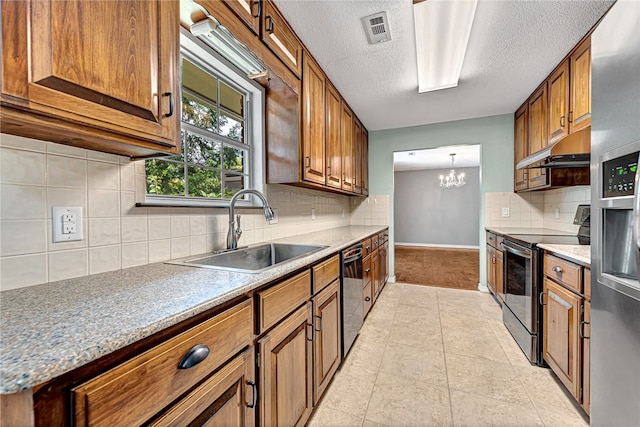 kitchen featuring stainless steel appliances, a chandelier, sink, decorative backsplash, and a textured ceiling