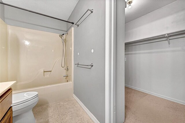 full bathroom featuring tile patterned floors, shower / washtub combination, toilet, vanity, and a textured ceiling