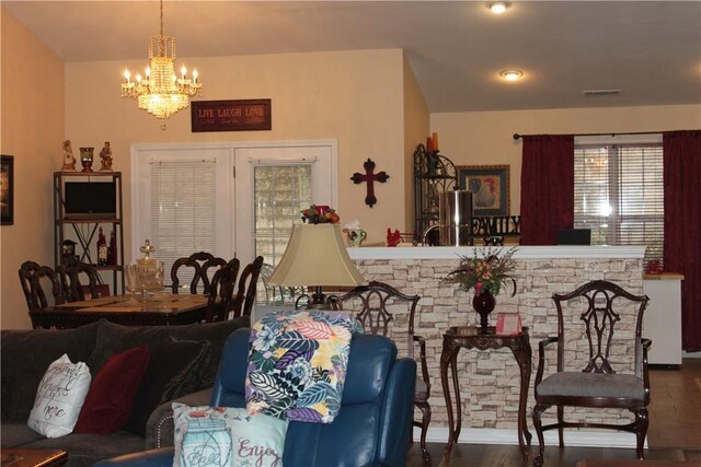 dining space featuring an inviting chandelier and a stone fireplace