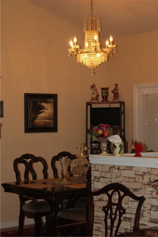 dining area featuring lofted ceiling and an inviting chandelier