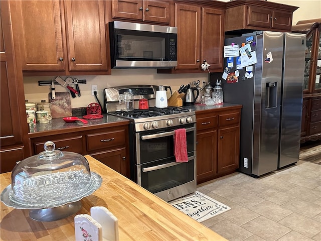 kitchen featuring appliances with stainless steel finishes and wood counters